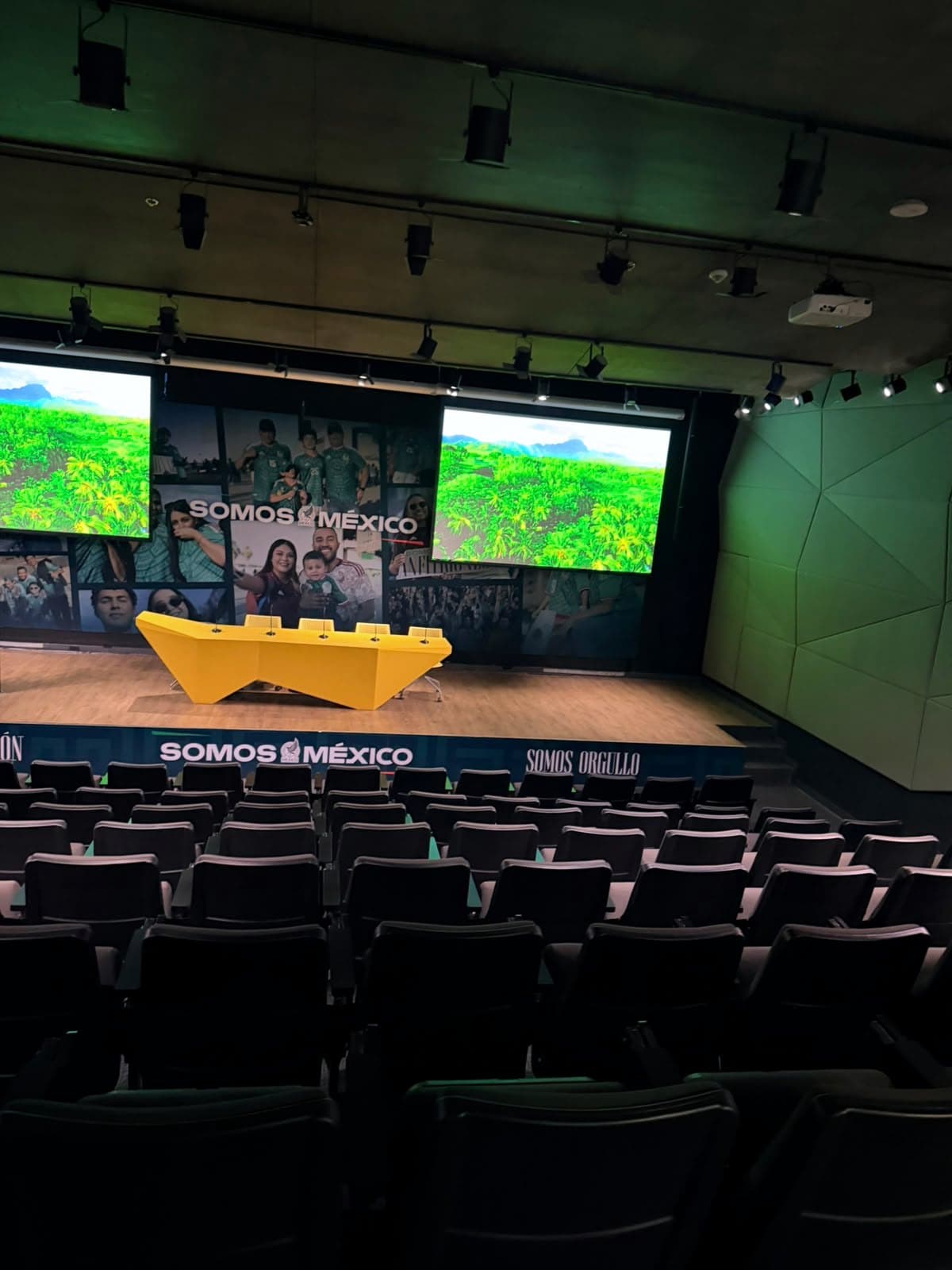 Fotografía de instalación ERCONNECT: auditorio institucional con doble videoproyección de gran formato operando, visto desde las butacas