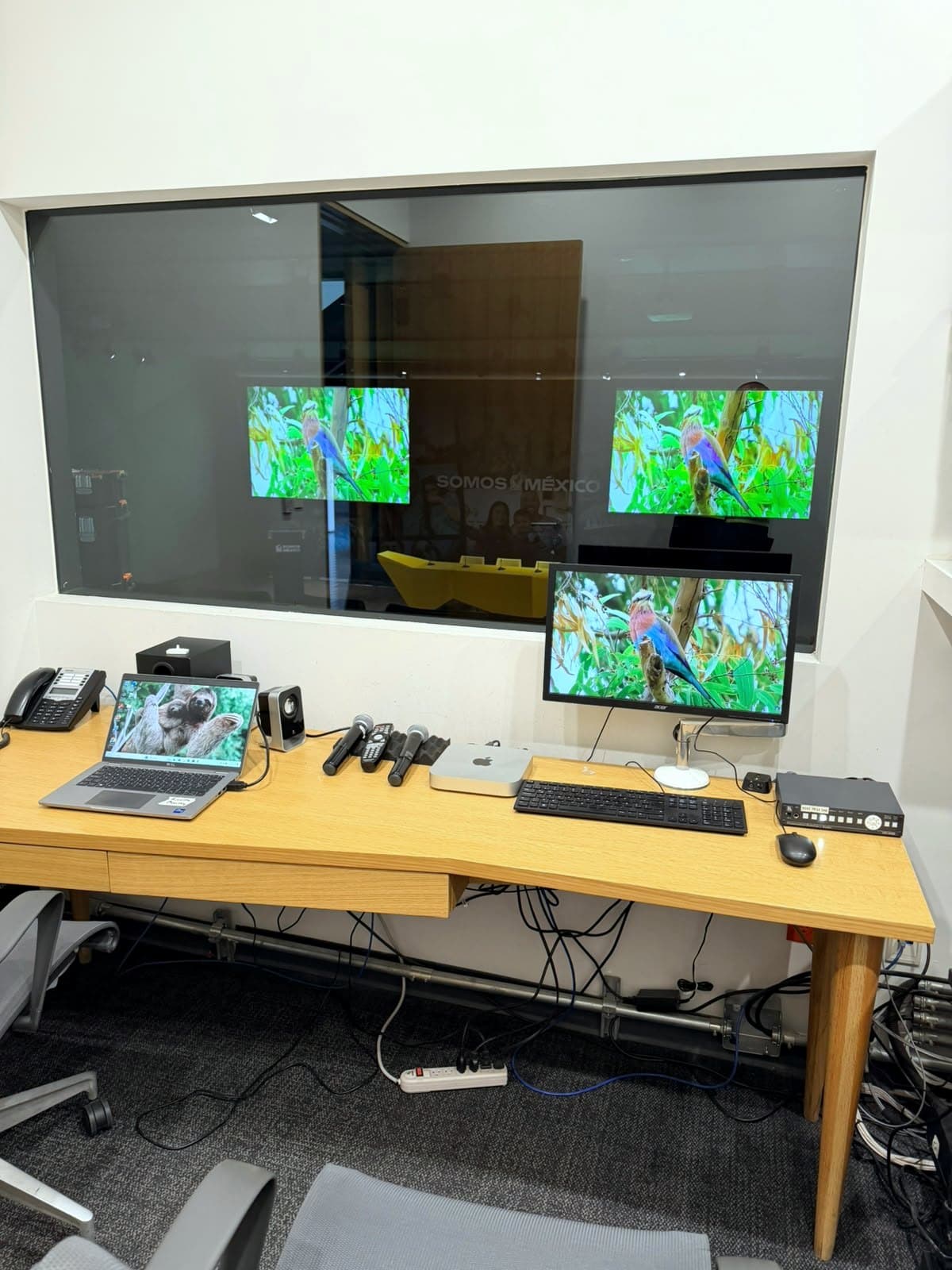 Fotografía del proyecto en la cabina de control del auditorio durante las pruebas, con la misma señal validada en el monitor de cabina y en ambas pantallas del recinto