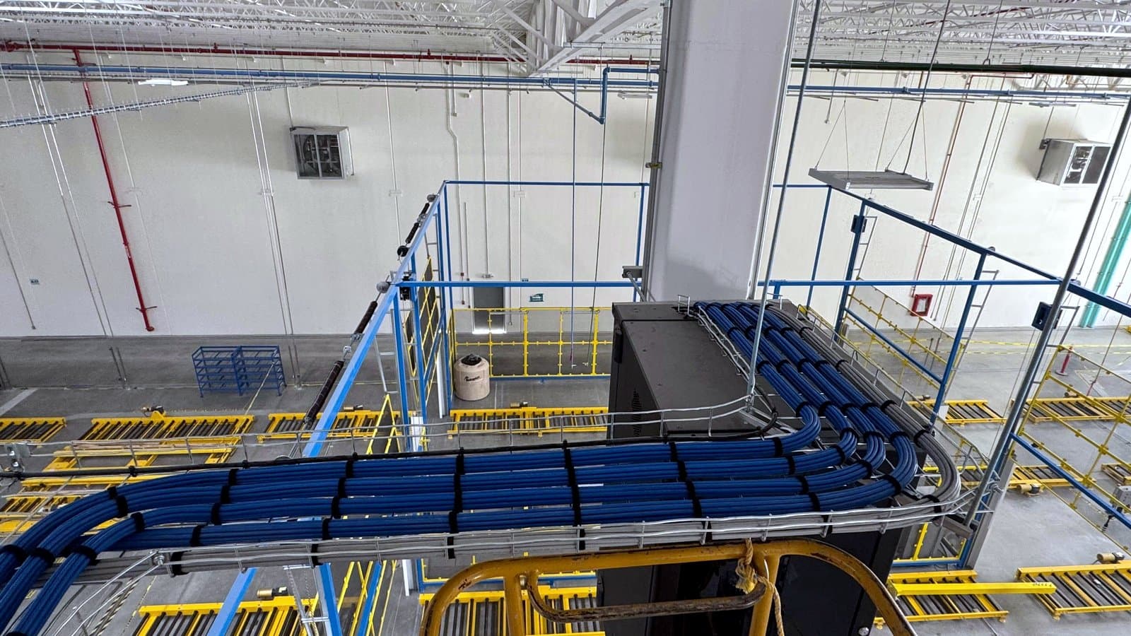 Fotografía de instalación ERCONNECT: charola con cableado estructurado cruzando sobre las áreas operativas de una planta industrial