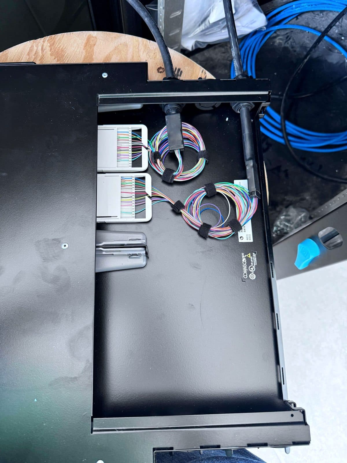 Fotografía de instalación ERCONNECT: interior de panel de fibra óptica con charolas de empalme y reservas de hilos administradas