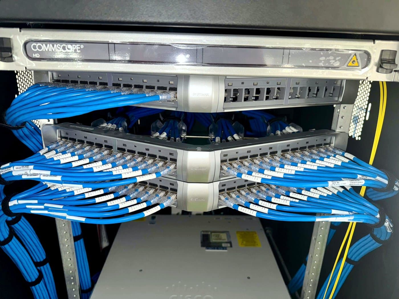 Fotografía de instalación ERCONNECT: panel de fibra óptica con administración de cordones azules