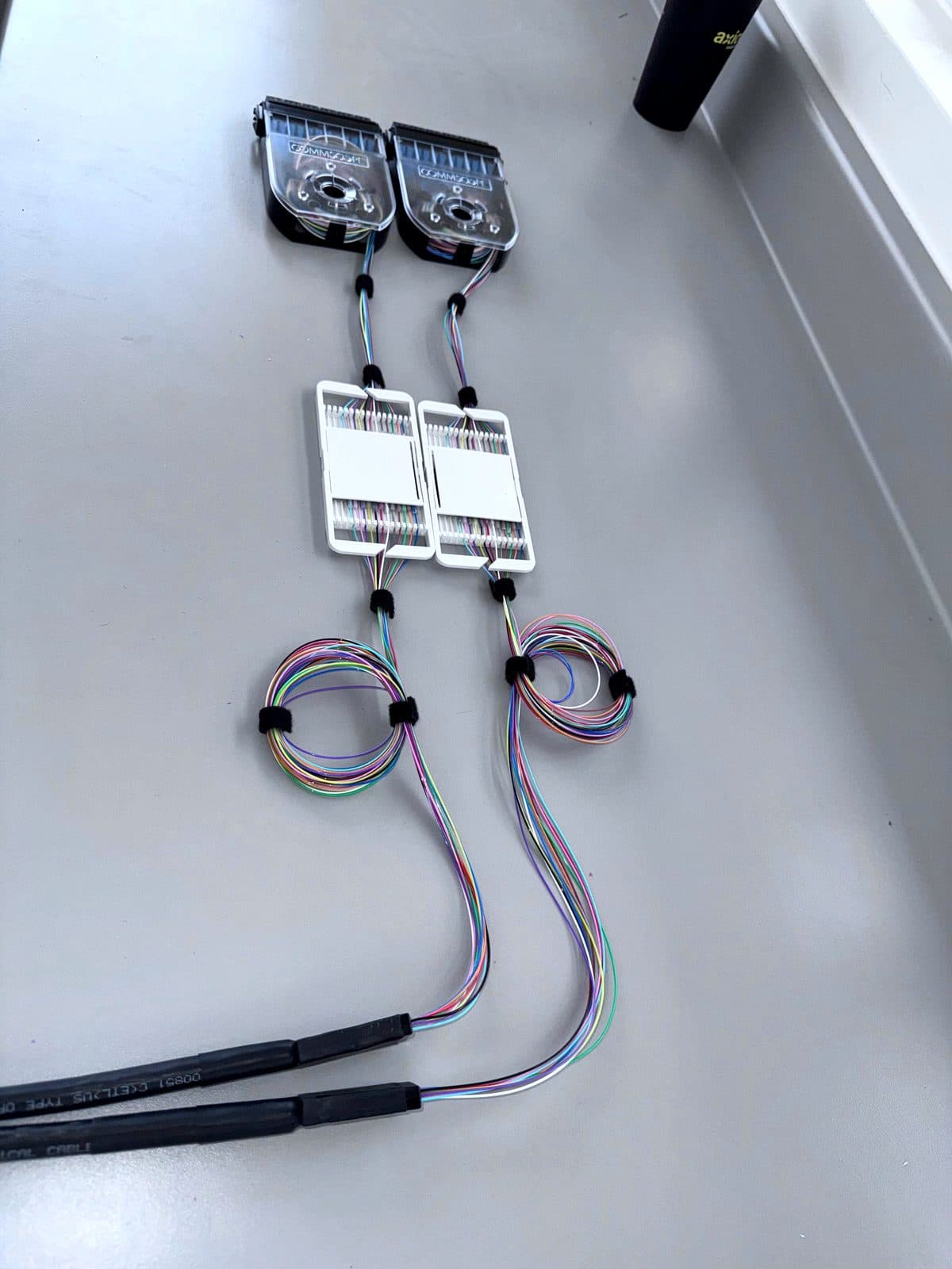 Fotografía de instalación ERCONNECT: preparación de charolas de empalme CommScope con hilos identificados por código de color y reservas aseguradas
