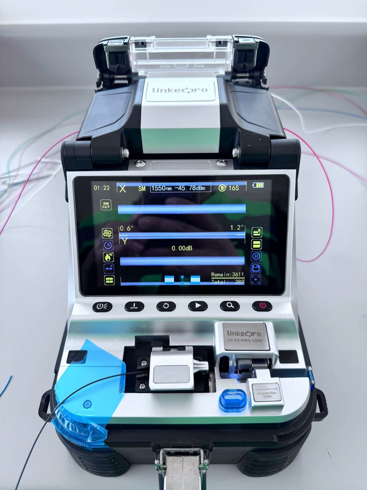 Fotografía de instalación ERCONNECT: empalmadora de fusión durante un ciclo de empalme de fibra monomodo, con alineación de núcleos X/Y en pantalla