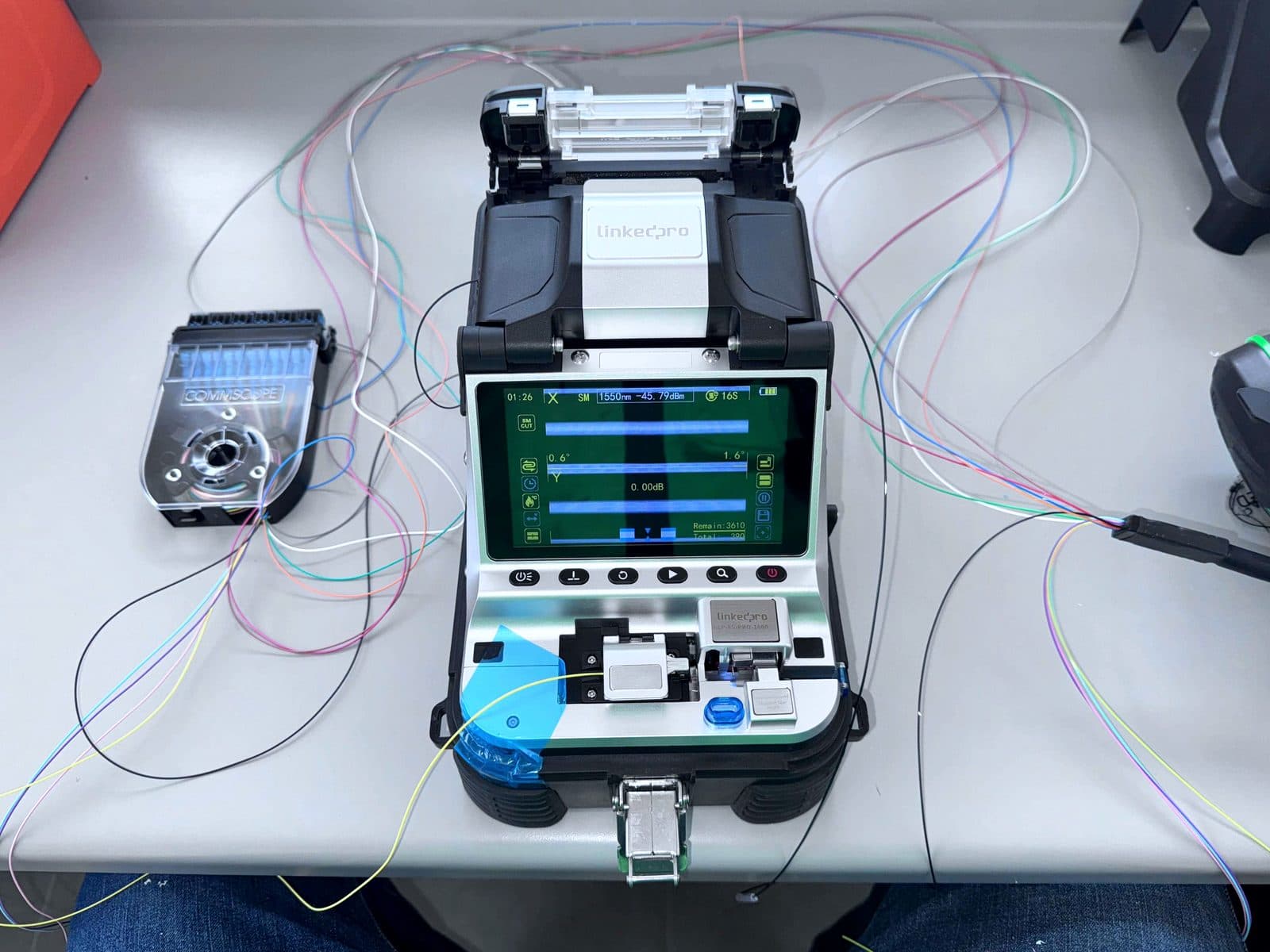 Fotografía de instalación ERCONNECT: estación de trabajo de fusión de fibra óptica con empalmadora, cortadora de precisión y herramienta de preparación sobre mesa