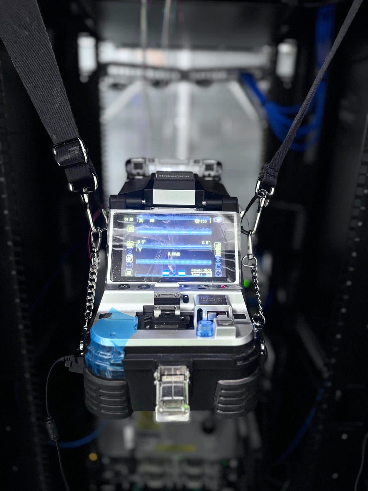 Fotografía de instalación ERCONNECT: empalmadora de fusión operando al pie del rack durante la terminación de un enlace de fibra óptica