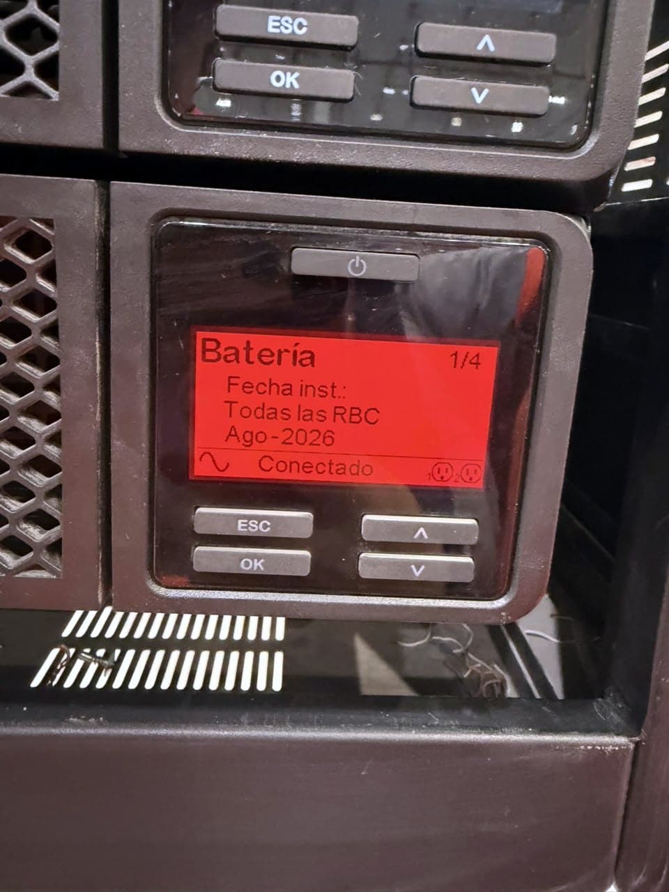 Fotografía de obra con la pantalla de un UPS de rack que muestra la fecha de instalación de sus baterías nuevas